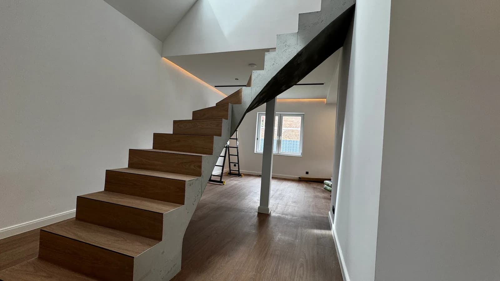 Betontreppe mit Holzstufen und indirekter LED-Beleuchtung, noch im Ausbau