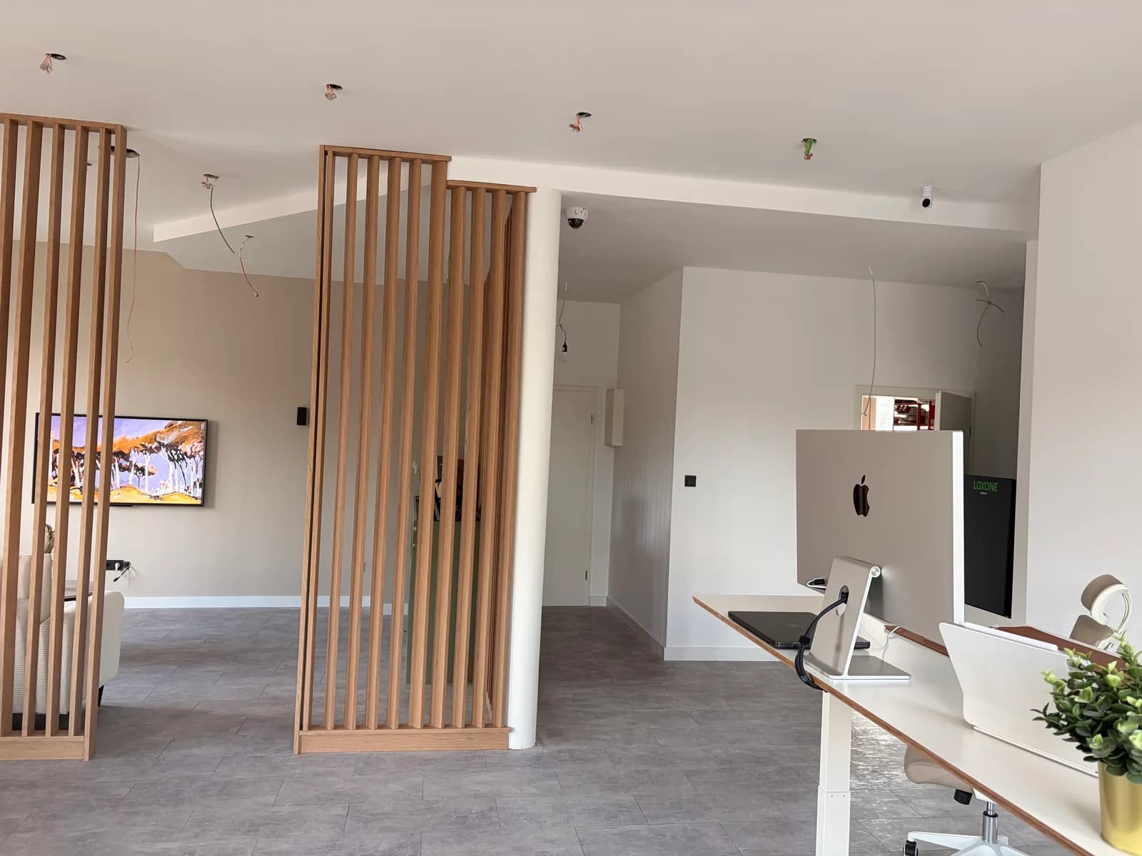 Showroom im Ausbau: Raumteiler aus Eiche stehen, aus der Decke hängen noch offene Leitungsenden